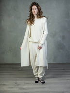 Female model wearing a Lynne Coleman cashmere jumper, hooded yacht wrap and jogger in colour cream
