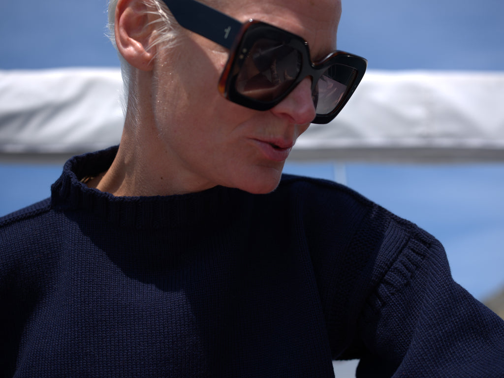 Model Anna Freemantle Zee wearing a Navy Lynne Coleman Cashmere Guernsey on a yacht