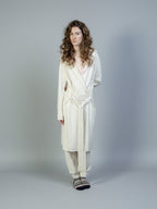 Female model wearing a Lynne Coleman cashmere jumper, hooded yacht wrap and jogger in colour cream and Fair Isle luxury cashmere socks